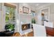 Cozy living room with a white brick fireplace, hardwood floors, and large windows at 6830 Vickery Creek Rd, Cumming, GA 30040