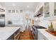 White kitchen with stainless steel appliances and hardwood floors at 6830 Vickery Creek Rd, Cumming, GA 30040