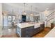 Open concept kitchen with large island, white cabinets and a farmhouse sink at 6830 Vickery Creek Rd, Cumming, GA 30040