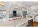 Elegant kitchen featuring marble countertops, farmhouse sink, and open floor plan flowing into the living area with a fireplace at 6830 Vickery Creek Rd, Cumming, GA 30040