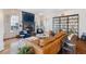 Cozy living room featuring hardwood floors, a stone fireplace, large windows, and a stylish bookshelf at 6830 Vickery Creek Rd, Cumming, GA 30040