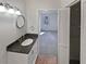 Bathroom with granite countertop vanity, a round mirror, and a linen closet at 2007 Variations Ne Dr, Atlanta, GA 30329