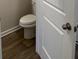 A neutral bathroom features wood-look floors and a standard toilet at 107 Meadowview Dr # 23, Temple, GA 30179