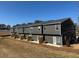 Row of newly constructed townhomes with gray siding and individual patios overlooking an expansive lawn at 107 Meadowview Dr # 23, Temple, GA 30179