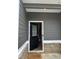 Welcoming covered entryway with a black front door and neutral-colored siding at 107 Meadowview Dr # 23, Temple, GA 30179