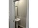 A small powder room features a pedestal sink and a gray mirror at 107 Meadowview Dr # 23, Temple, GA 30179