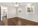 Bedroom showcasing hardwood floors and natural light from two windows, door to the kitchen at 1723 Capistrana Pl, Decatur, GA 30032