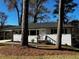 Charming single-story home with white brick exterior and mature trees providing shade at 1723 Capistrana Pl, Decatur, GA 30032