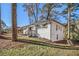 Exterior view of a single-story white brick home with mature trees and a well-manicured lawn at 1723 Capistrana Pl, Decatur, GA 30032