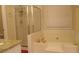 Bright bathroom featuring a glass shower, a soaking tub, and a large window at 2562 Pendergrass Ct, Ellenwood, GA 30294