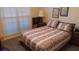 Bedroom with window and blinds, bedside tables, lamps, and a comfortable bed at 2562 Pendergrass Ct, Ellenwood, GA 30294