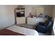 Comfortable bedroom featuring a TV and shelving unit, dresser with mirror and an armchair at 2562 Pendergrass Ct, Ellenwood, GA 30294