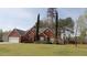 All brick home showcasing a well-groomed yard, two-car garage, and elegant window trim at 2562 Pendergrass Ct, Ellenwood, GA 30294