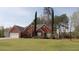 Classic brick home with a lush green lawn, two-car garage, and meticulously maintained landscaping at 2562 Pendergrass Ct, Ellenwood, GA 30294