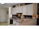 A kitchen features granite countertops and white cabinets with black and yellow tiled backsplash at 2562 Pendergrass Ct, Ellenwood, GA 30294