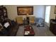 Comfortable living room featuring a brown leather couch, patterned chairs, and a decorative painting at 2562 Pendergrass Ct, Ellenwood, GA 30294