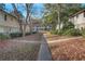 Exterior view of a townhouse community with mature trees, landscaping, and walkways at 6940 Roswell Rd # E12, Atlanta, GA 30328