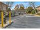 Gated community entrance with yellow bollards and well-maintained landscaping at 6940 Roswell Rd # E12, Atlanta, GA 30328