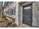 Charming townhome entrance featuring a dark front door and manicured landscaping along the facade at 6940 Roswell Rd # E12, Atlanta, GA 30328