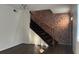 Living room featuring a decorative brick wall and hardwood stairs with black painted risers at 6940 Roswell Rd # E12, Atlanta, GA 30328