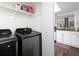 Laundry room with modern washer and dryer, plus storage shelves, conveniently located near the kitchen at 75 Fair Haven Se Way, Smyrna, GA 30080