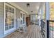 Charming back porch with a rocking chair and rustic wood pile and wood plank flooring at 3975 Mcconnell Rd, Cumming, GA 30028