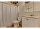 Bathroom featuring a striped shower curtain, toilet, sink and vanity with a light wall color at 3975 Mcconnell Rd, Cumming, GA 30028