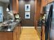 Stylish kitchen featuring stainless appliances, wood cabinets and floors, and granite countertops at 855 Peachtree Ne St # 2306, Atlanta, GA 30308