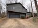 Gray sided two-story house with attached garage and landscaped yard at 5042 Post Road Trl, Stone Mountain, GA 30088