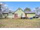 Back exterior showcasing the backyard, red doors and ample greenery at 275 Helen Ln, Stockbridge, GA 30281