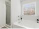 Bright bathroom with tub, shower, and large window at 4192 Integrity Way, Powder Springs, GA 30127