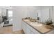 Double vanity bathroom with dual sinks and a view into a bedroom with comfortable sitting area at 142 Oakchase Park Ln, Hampton, GA 30228