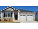 Charming one-story home with two-car garage, black door, and manicured lawn at 142 Oakchase Park Ln, Hampton, GA 30228