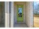 Charming front door with glass, surrounded by brick facade and green paint at 1416 Lucan Ln # Wc220, Lawrenceville, GA 30043