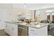 Kitchen island with granite countertop, stainless dishwasher, open floor plan, and wine glasses at 1416 Lucan Ln # Wc220, Lawrenceville, GA 30043