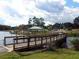 Scenic lake view featuring a wooden boardwalk, gazebo, and surrounding greenery in a tranquil setting at 1416 Lucan Ln # Wc220, Lawrenceville, GA 30043