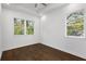 Bright bedroom with tray ceiling, hardwood floors, and three windows offering a view of the trees at 60 Newcastle Sw St, Atlanta, GA 30314
