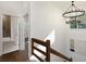 Hallway with wood railing, chandelier, hardwood floors, and view of bathroom at 60 Newcastle Sw St, Atlanta, GA 30314