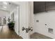 Bright laundry room with gray cabinets and a view into the entry hall with hardwood floors at 60 Newcastle Sw St, Atlanta, GA 30314