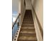 Carpeted staircase with wood railing and black wrought-iron balusters at 109 Meadowview Dr # 22, Temple, GA 30179