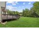 A view of the expansive backyard, deck, and lawn with mature trees at 2852 Emerson Lake Dr, Snellville, GA 30078