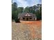 Exterior view of a new home under construction with a dark roof and light wood framing surrounded by trees at 542 Palm St, Holly Springs, GA 30115