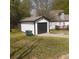 Exterior shot of the detached garage, featuring a black door, white trim and siding, and paved driveway at 333 Pickfair Sw Way, Atlanta, GA 30315