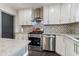 Charming kitchen featuring white cabinets, stainless steel appliances, and herringbone tile backsplash at 1770 South Olympian Sw Way, Atlanta, GA 30310