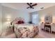 Charming bedroom with floral bedding, decorative headboard, side table, and vanity with stool and mirror at 9031 Par Dr, Douglasville, GA 30134