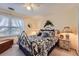 Well-lit bedroom with floral bedding, window, chest of drawers, and wicker nightstand lamps at 9031 Par Dr, Douglasville, GA 30134