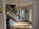 Inviting foyer features hardwood floors, staircase, and natural light streaming through the decorative glass front door at 9031 Par Dr, Douglasville, GA 30134