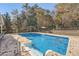 Backyard inground pool with a diving board, patio, pergola, and mature trees, for outdoor enjoyment at 9031 Par Dr, Douglasville, GA 30134