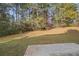 A relaxing backyard showcasing a private setting surrounded by mature trees and lush greenery at 90 Loudoun Dr, Covington, GA 30014