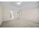 Spacious bedroom with neutral walls, plush carpet, and a door to the ensuite at 90 Loudoun Dr, Covington, GA 30014